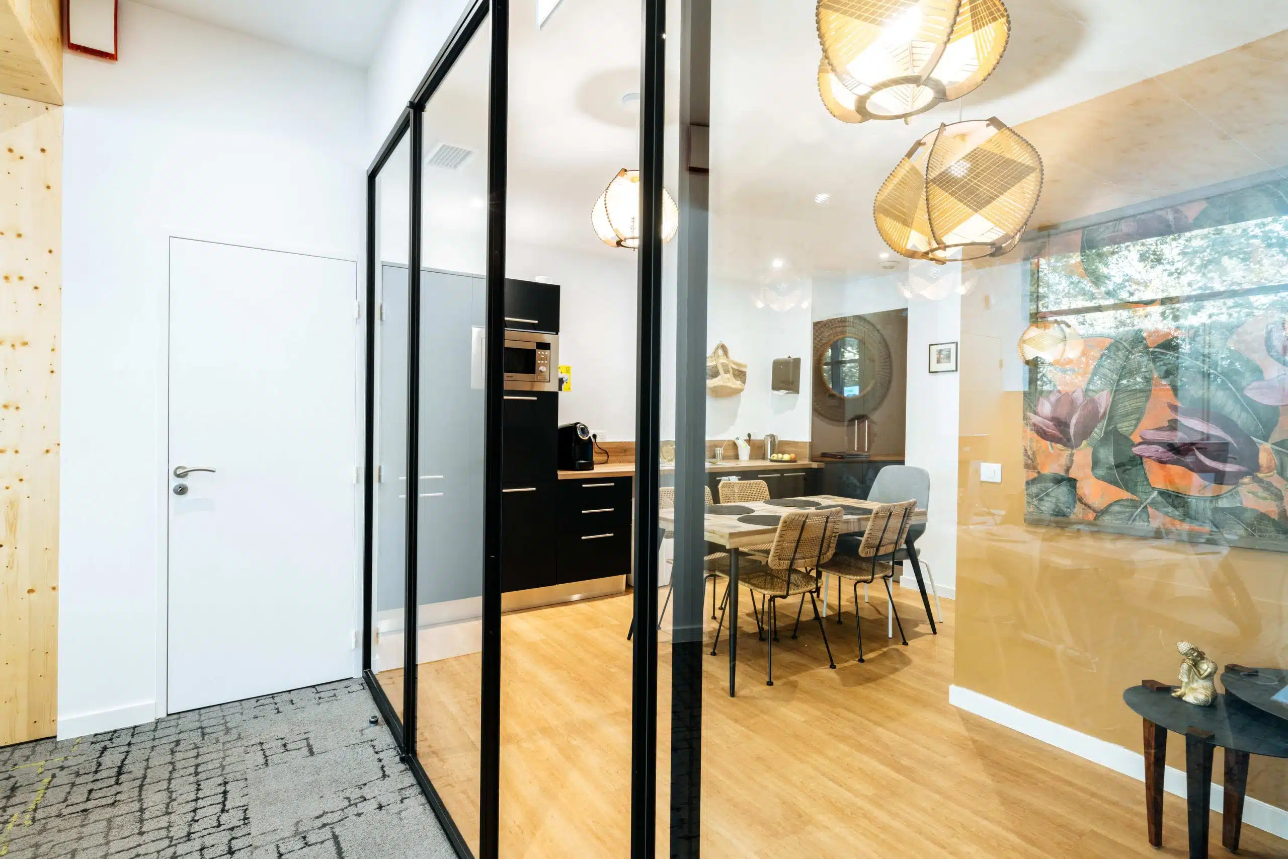 Vue intérieure avec cloison vitrée et bois dans l’agence Nexity Port Marianne à Montpellier