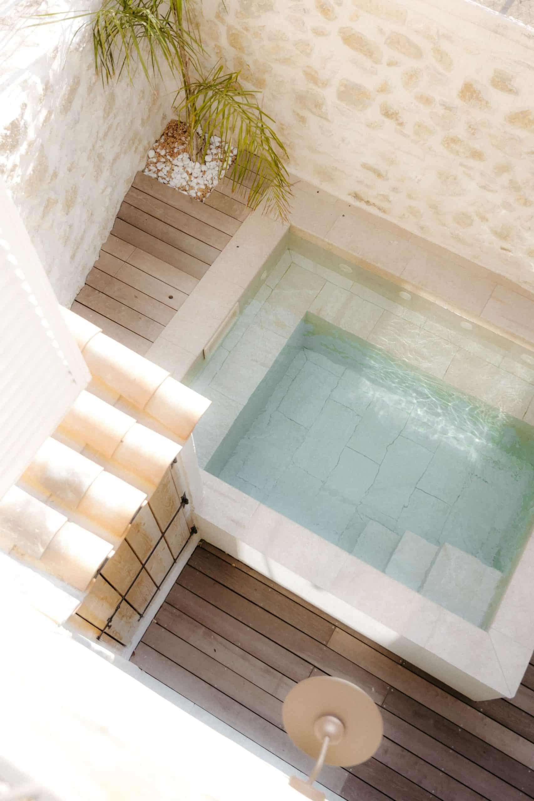 Bassin extérieur en pierre et terrasse bois – Maison Montpellier