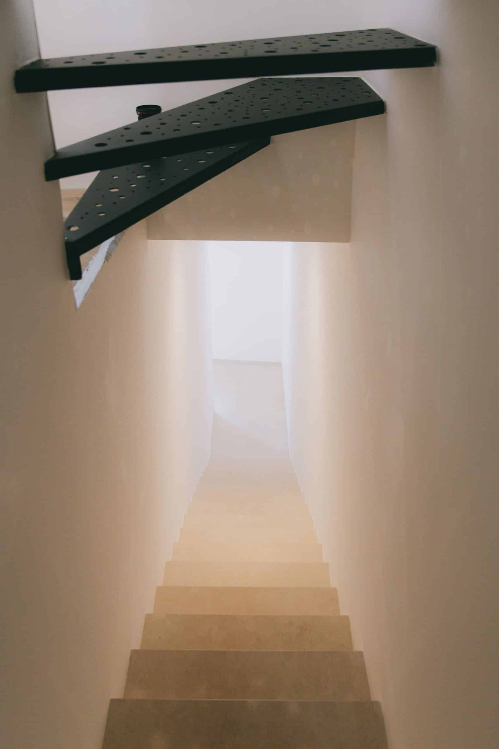 Escalier minimaliste en acier noir et pierre claire