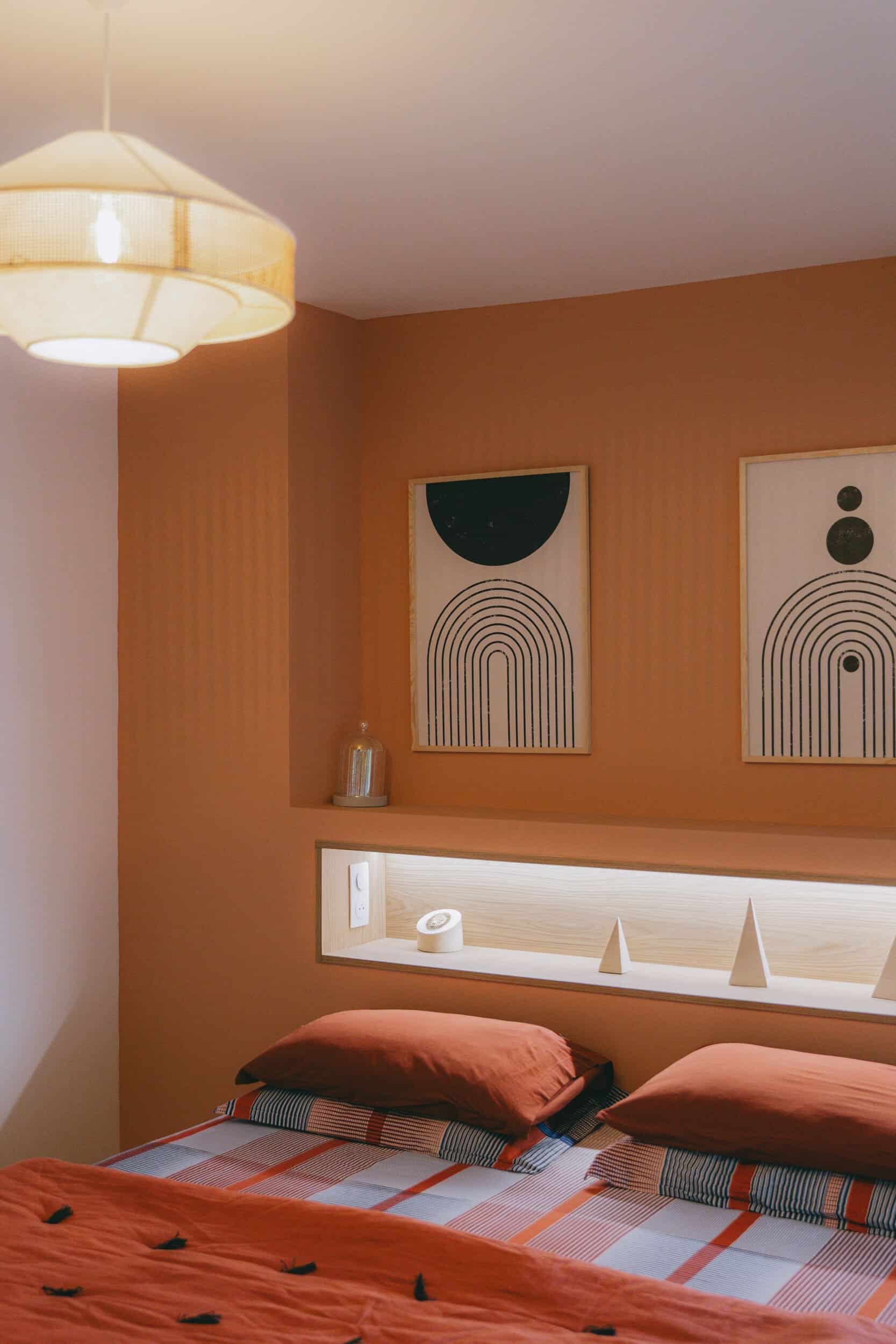 Chambre terracotta avec niche lumineuse et tableaux graphiques – La Grande-Motte