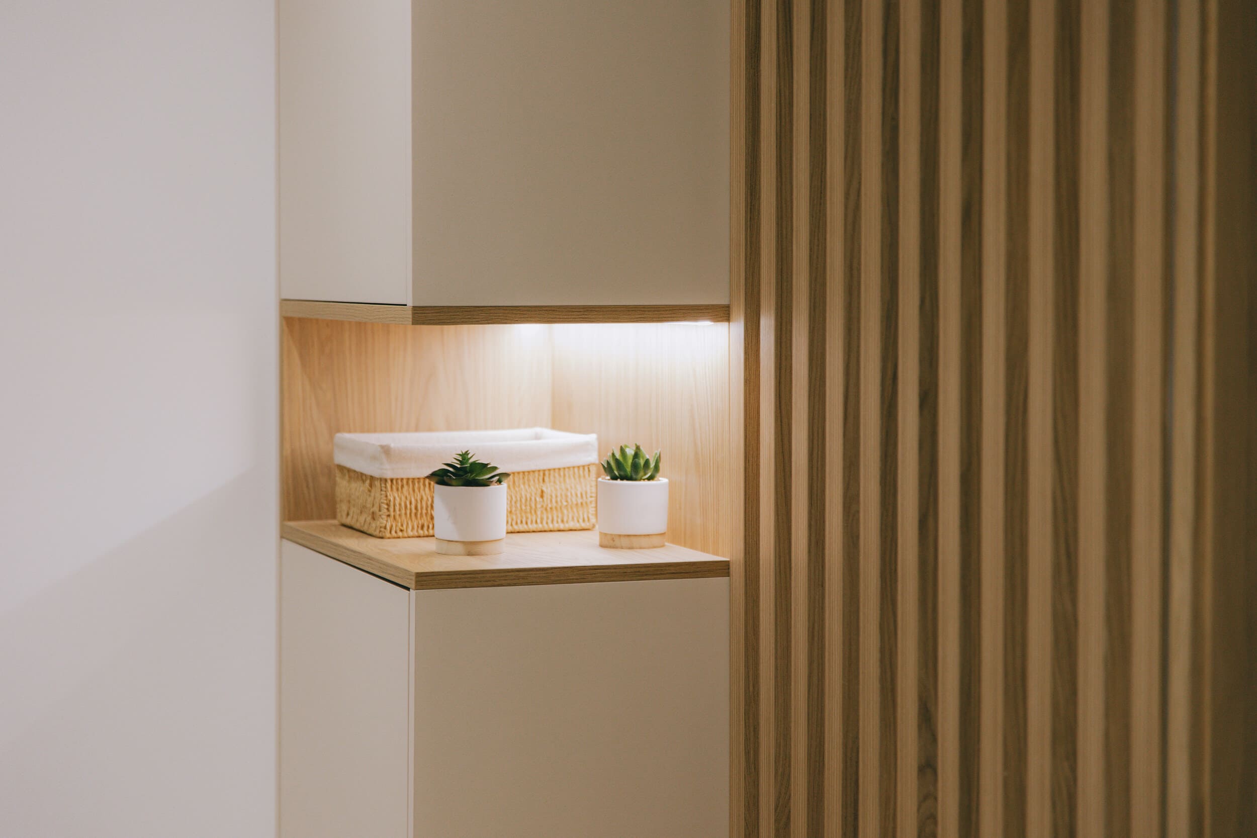 Vue d’ensemble du couloir et meuble sur mesure avec claustra en bois – La Grande-Motte