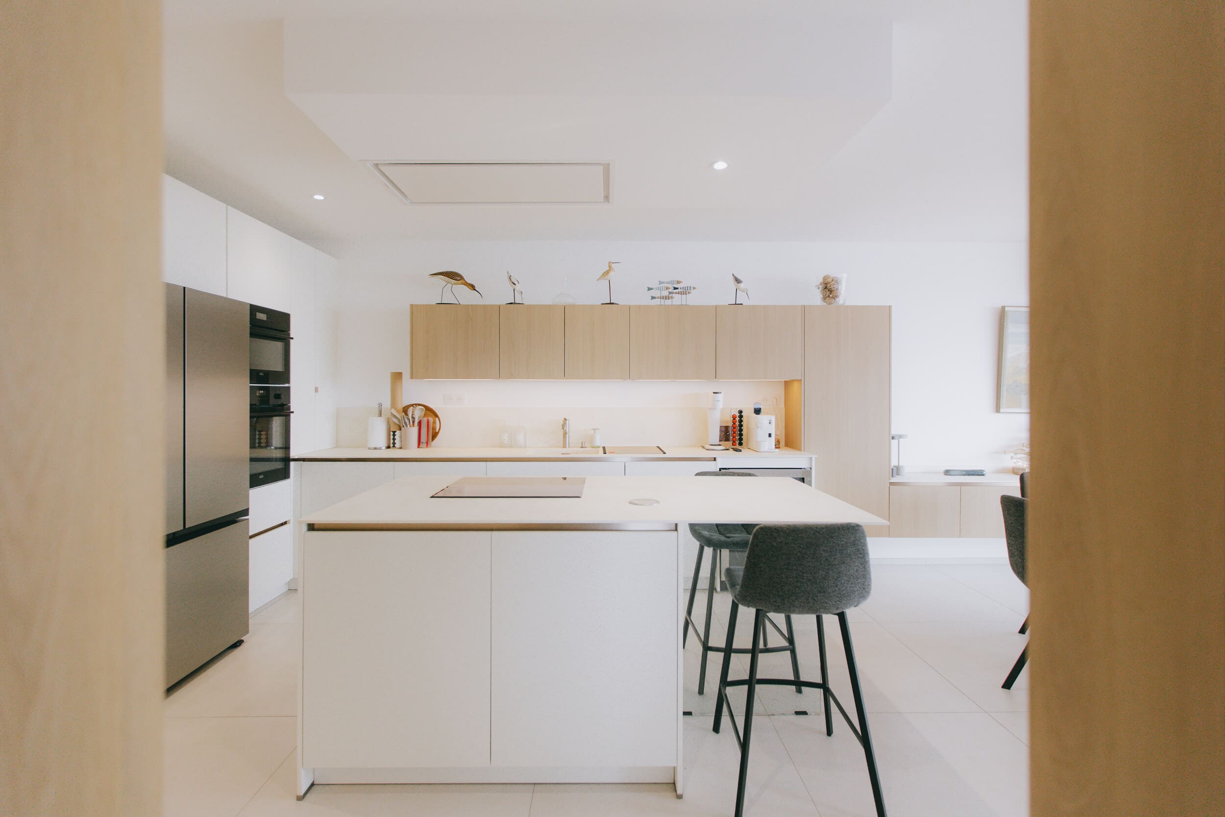 Cuisine contemporaine avec îlot central et meubles en bois clair – La Grande-Motte