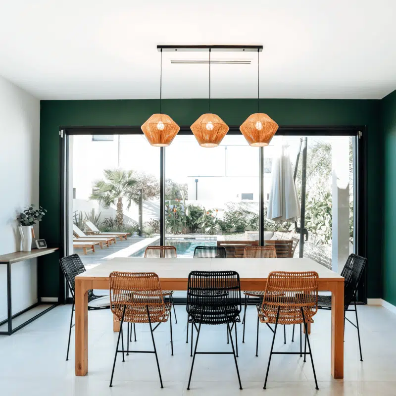 séjour salle à manger murs verts avec vue sur la piscine par l'agence Dugas à Montpellier