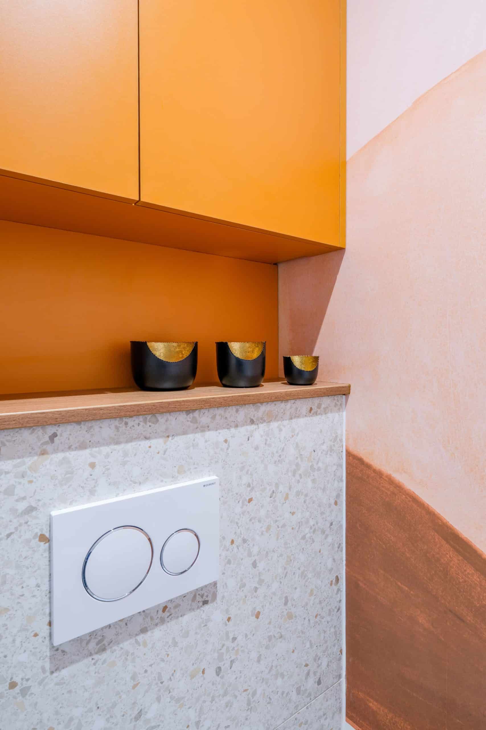 WC design avec niche colorée et revêtement terrazzo