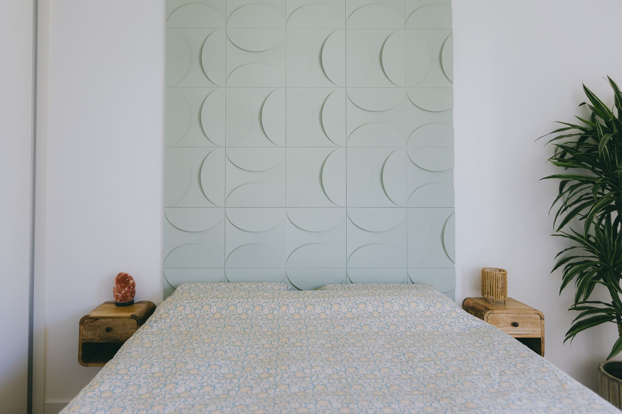 Aménagement d'une chambre avec une tête de lit sur mesure géométrique vert d'eau et tables de chevet suspendues en bois, rénovation d'appartement à Montpellier