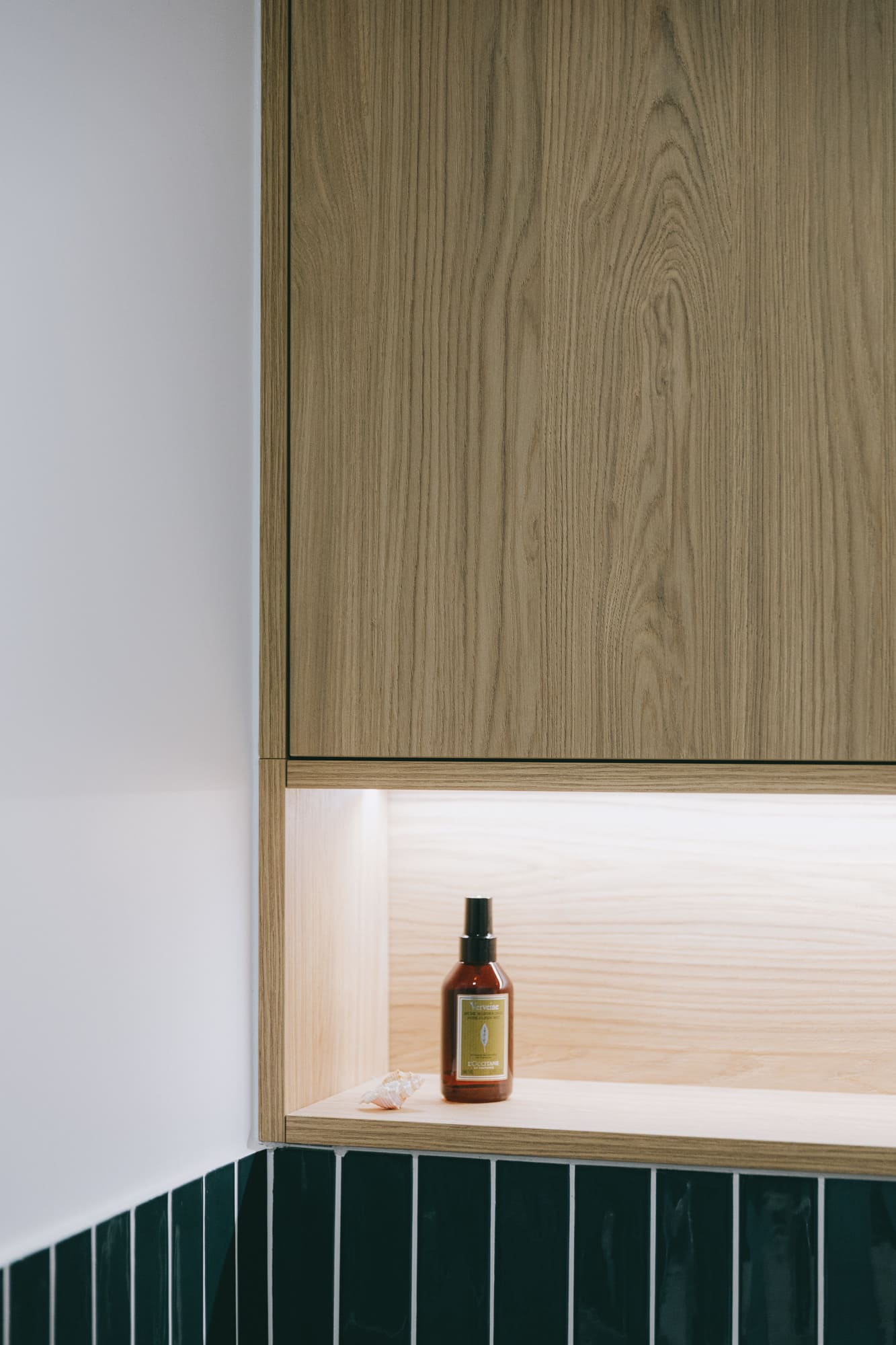 Détail d'un meuble de salle de bain en bois sur mesure avec niche éclairée, appartement Orion à Montpellier