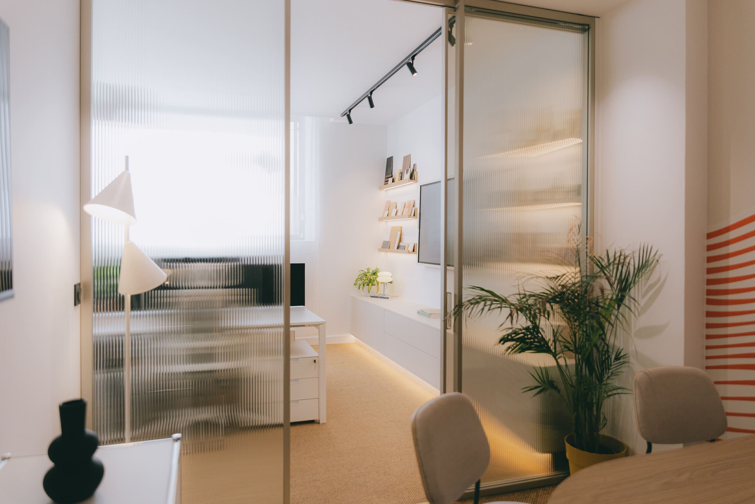 Projet complet d'architecture d'intérieur intégrant bureaux, salle de réunion, rangements sur mesure et matériaux nobles pour un espace professionnel élégant