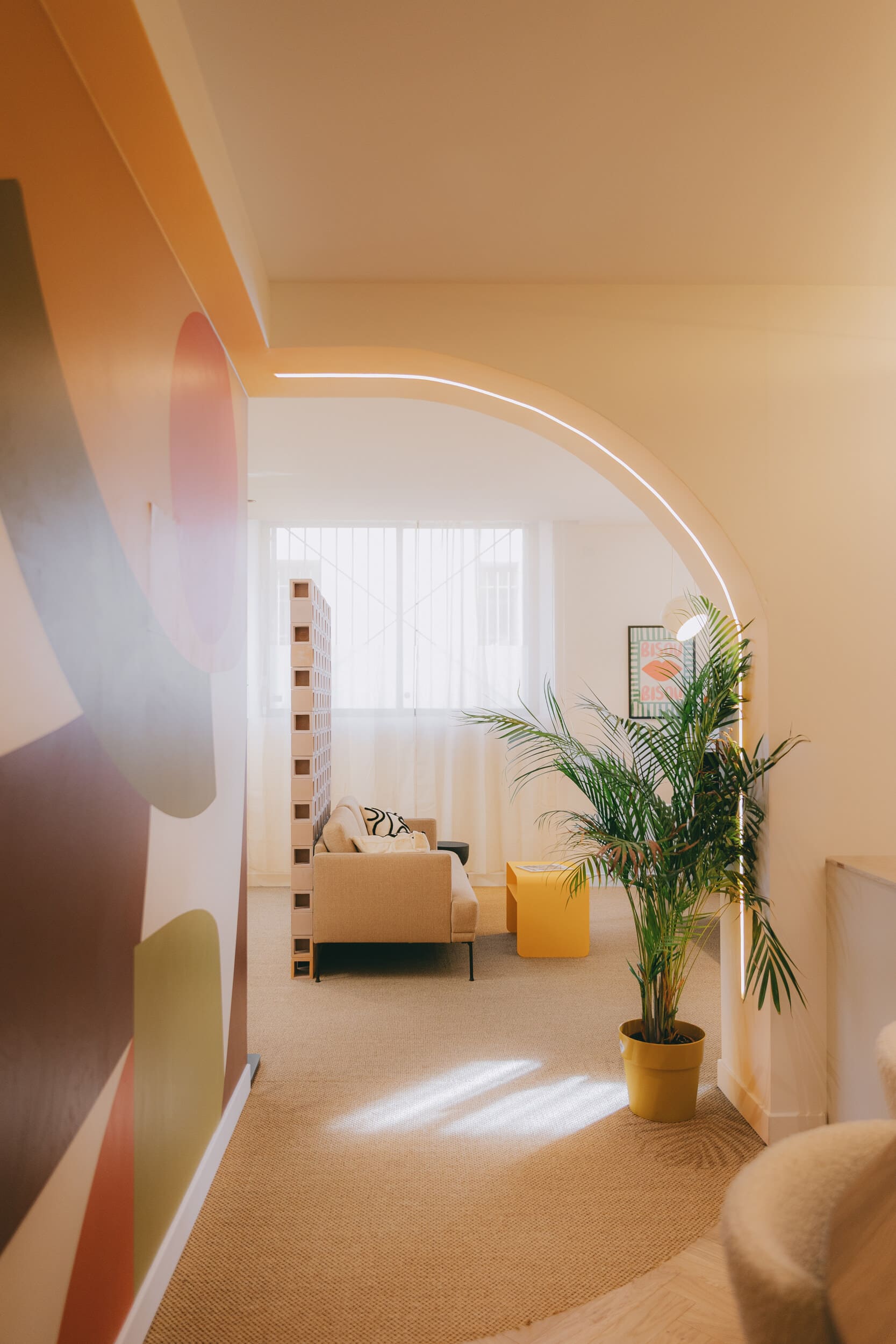 Perspective d'un intérieur contemporain mettant en valeur une arche éclairée, une fresque murale et une ambiance élégante et chaleureuse