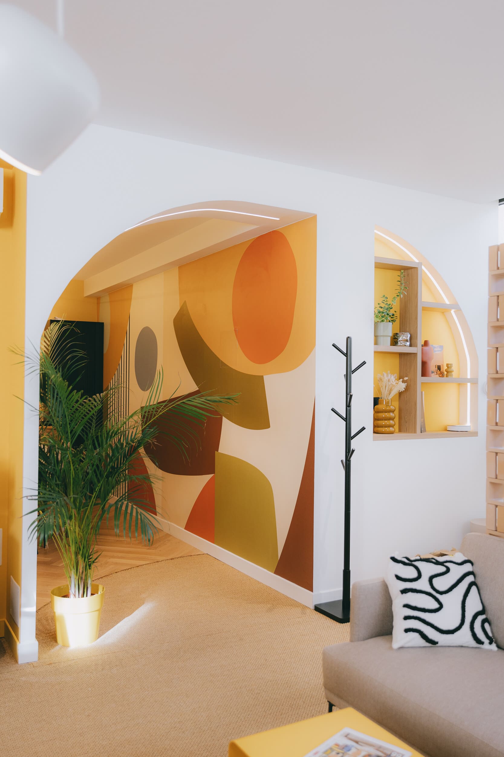 Entrée contemporaine avec arche, fresque graphique et mobilier sur mesure réalisée par Jeremy Dugas, architecte d'intérieur spécialisé en rénovation haut de gamme