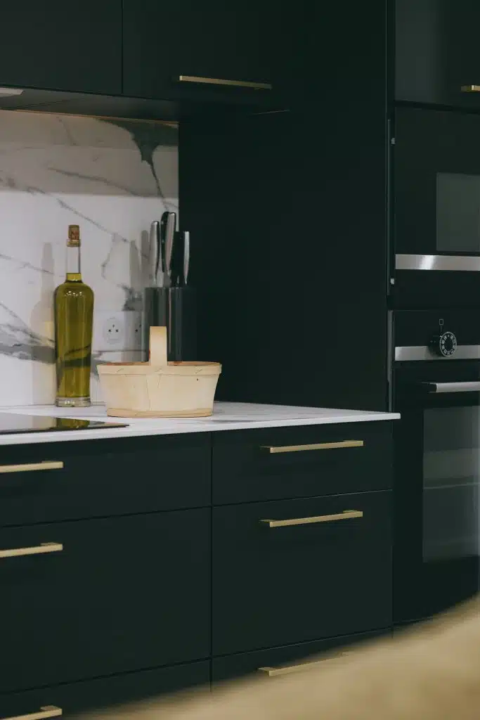 Plan de travail effet marbre et meubles noirs mats dans une cuisine contemporaine