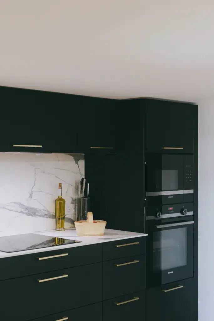 Colonnes de fours et micro-ondes encastrés dans une cuisine noire
