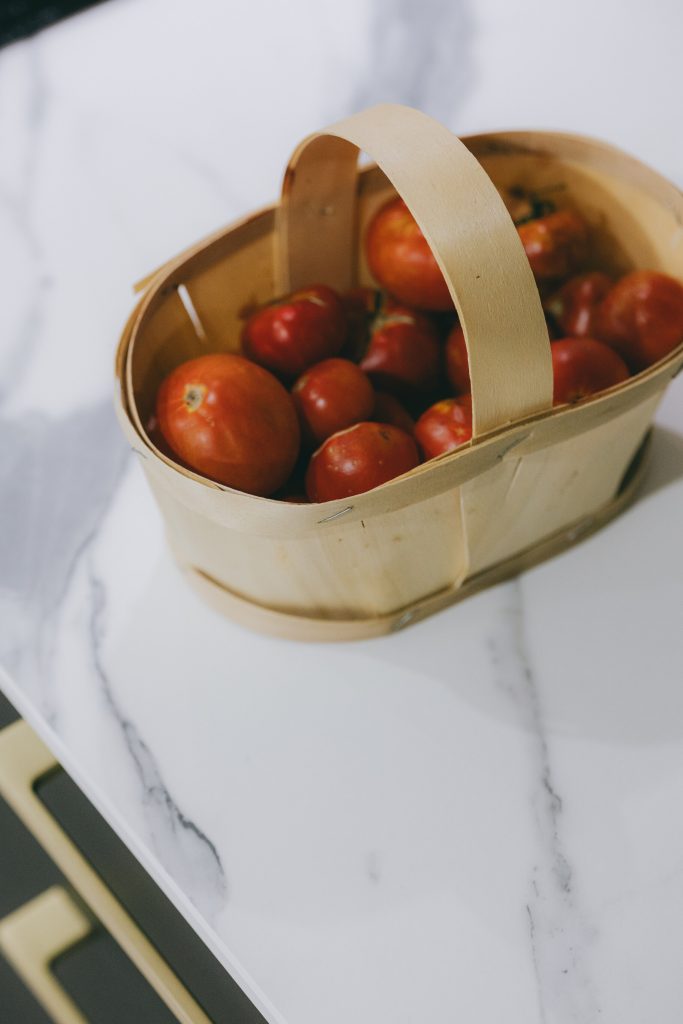 Panier de tomates posé sur un plan de travail effet marbre blanc