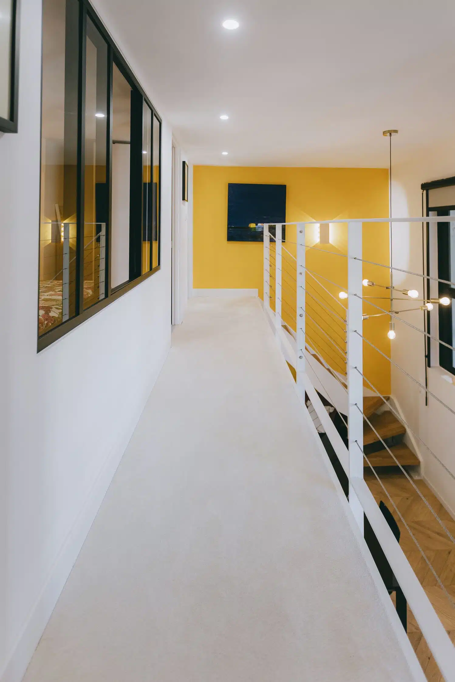 Coursive de la mezzanine bordée d'une verrière d'atelier noire