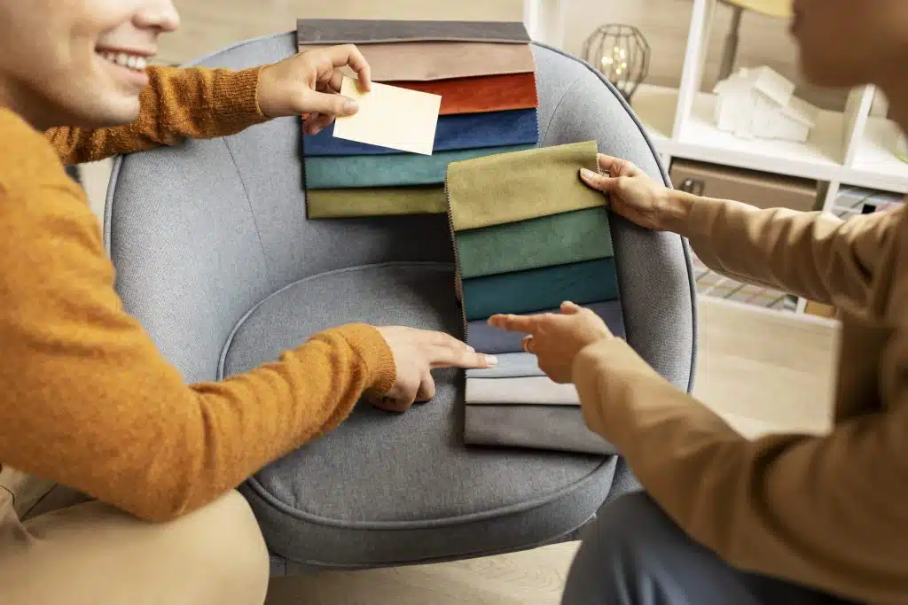 Décorateur d’intérieur présentant des échantillons de tissus à une cliente